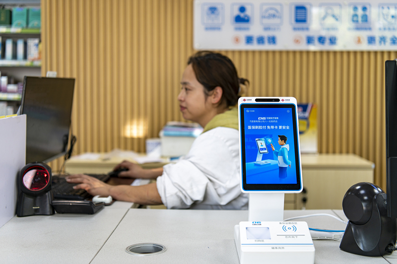 2024年4月10日，浙江金華市區(qū)一家民眾大藥房柜臺(tái)上設(shè)置著醫(yī)?！八⒛樦Ц丁睓C(jī)器，群眾看病更加便利。